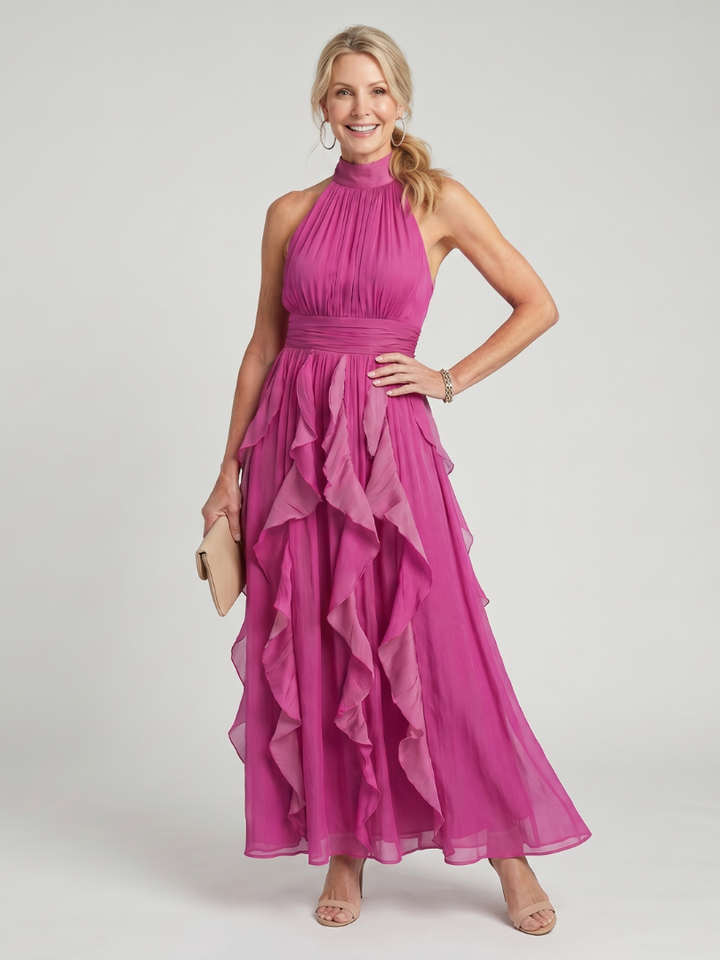Veda Bremen Orea maxi dress with high neckline, gathered fabric, and layered ruffle details featured in the image.