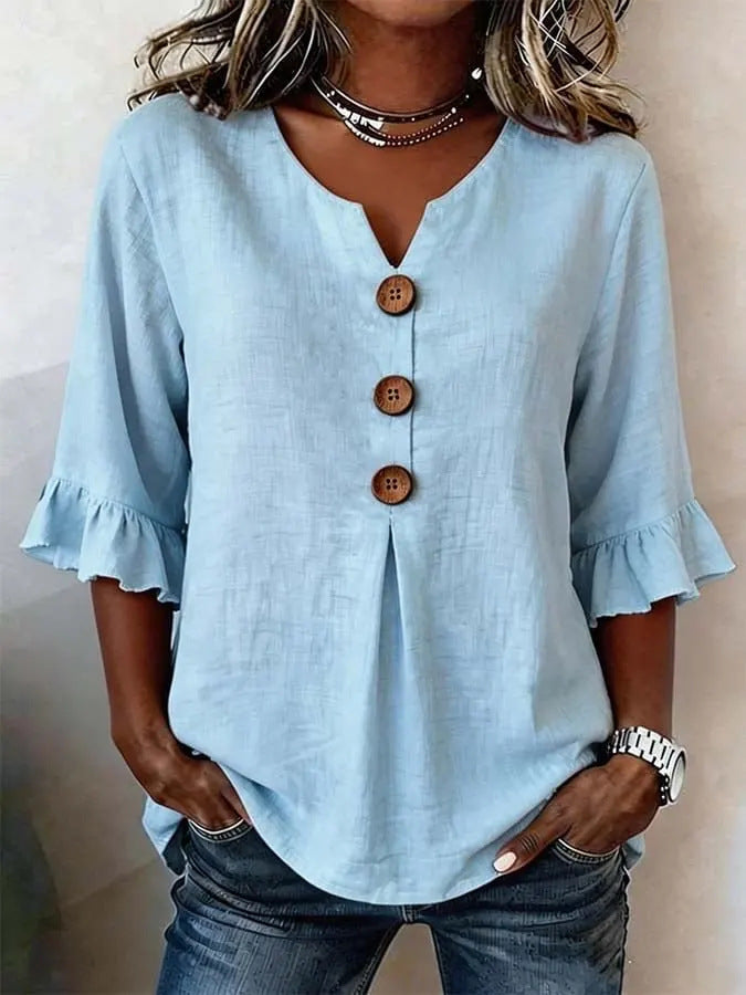 Veda Bremen Jessara linen blouse with ruffled sleeves, lightweight fabric, and feminine design, displayed on a hanger.