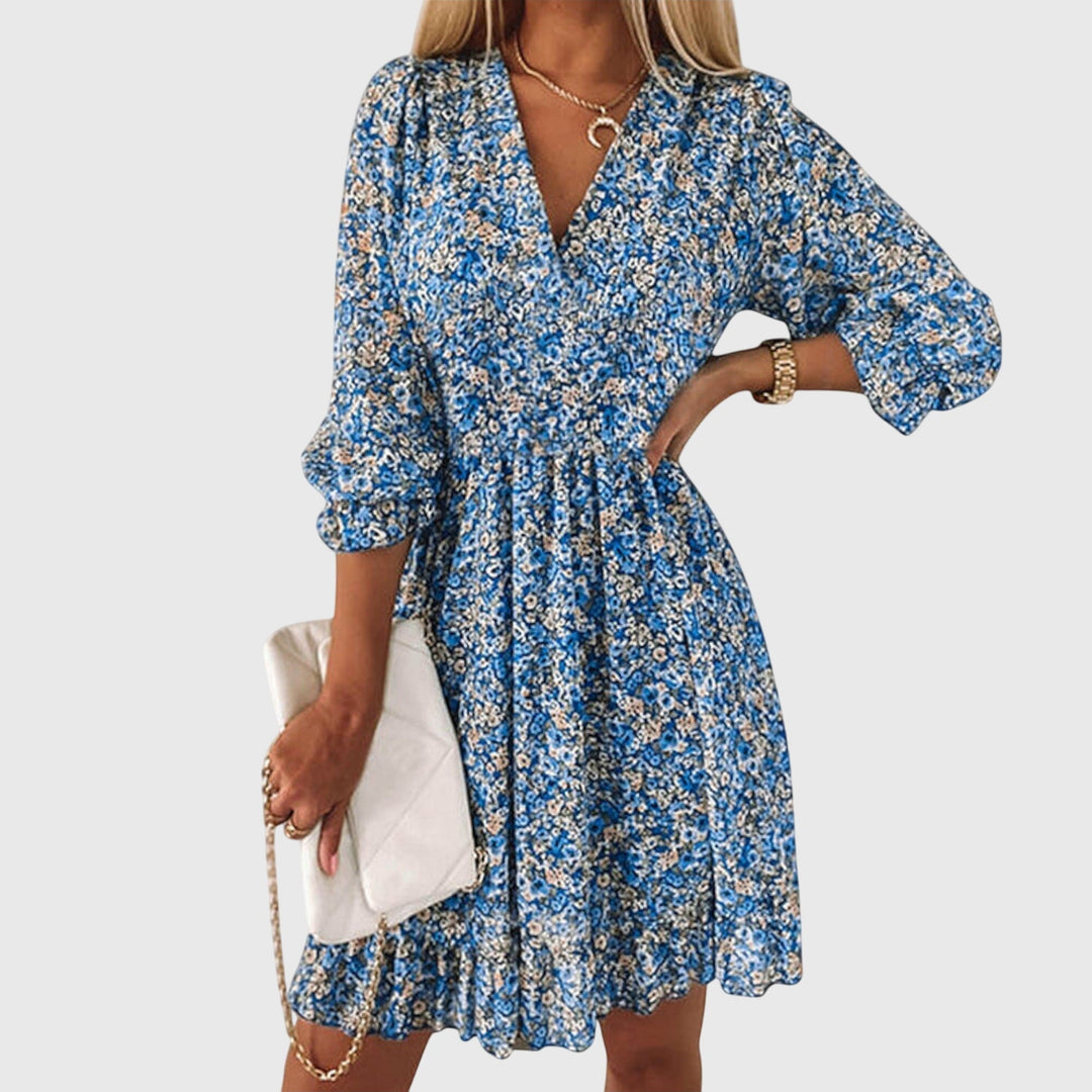 Veda Bremen Elisa floral puff-sleeve dress with a fitted bodice and flowing skirt, featuring vibrant floral patterns and puffed sleeves.