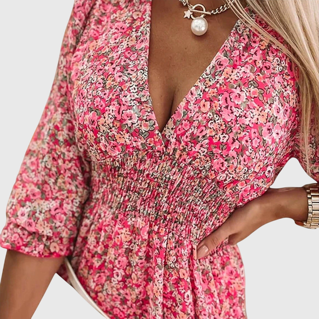 Veda Bremen Elisa floral puff-sleeve dress with a fitted waist and flowing skirt, displayed on a hanger against a white background.