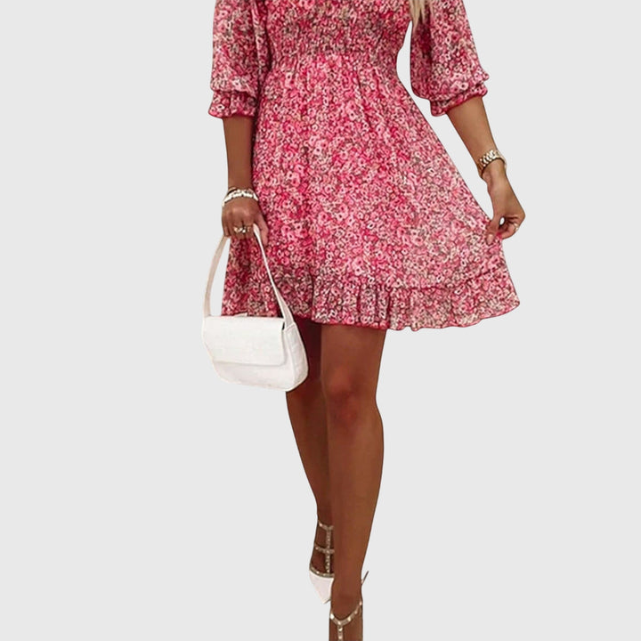 Veda Bremen Elisa floral puff-sleeve dress with a fitted bodice and flowing skirt, showcased with a floral pattern.