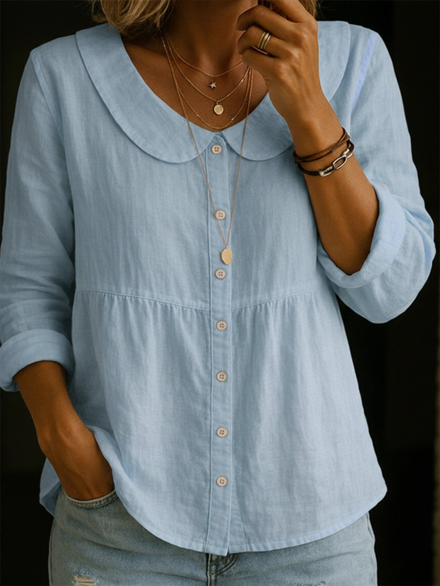 Veda Bremen Arlira linen blouse with Peter Pan collar, soft textured fabric and long sleeves, styled on a hanger.