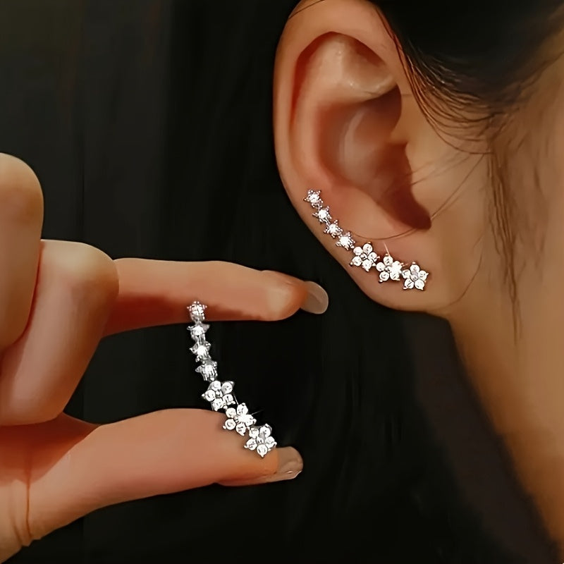 Veda Bremen zeitlose Blumen Ohrringe with intricate floral design and silver hooks, close-up view of the elegant jewelry.