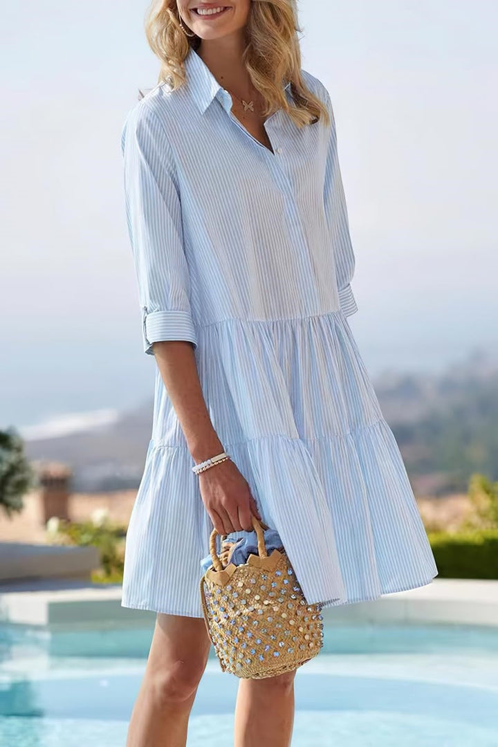 Blue Veda Bremen Sofia dress hanging on a wooden hanger, showcasing its simple, relaxed fit and elegant style.