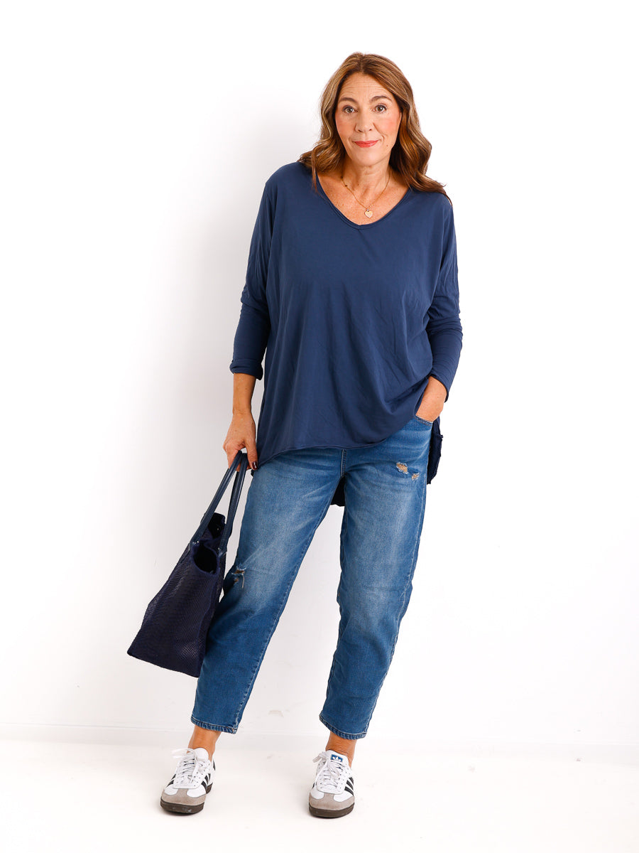 Veda Bremen Brenda long-sleeve shirt in a soft, neutral fabric, displayed on a hanger with a close-up of the fabric texture and fit.