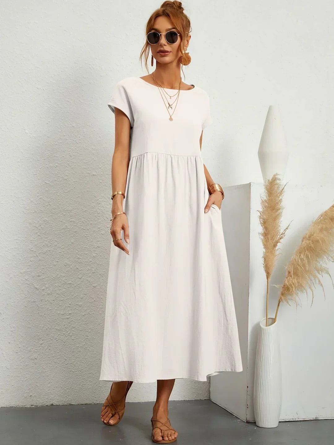 Veda Bremen Gabrielle Midikleid with flowing silhouette, featuring soft fabric and elegant design, worn by a model in a stylish setting.