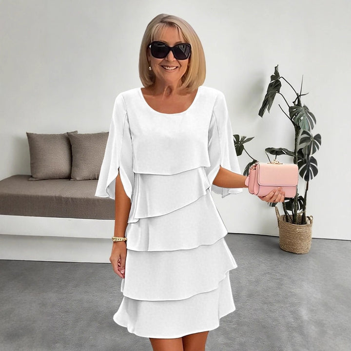 Veda Bremen layered dress with ruffles, featuring a feminine design and flowing fabric, perfect for elegant occasions.