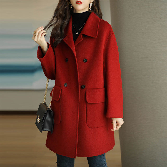 Red Mila Luxe Cashmere Coat by Lurolondon.co.uk displayed on a hanger, showcasing its soft cashmere fabric and tailored design.