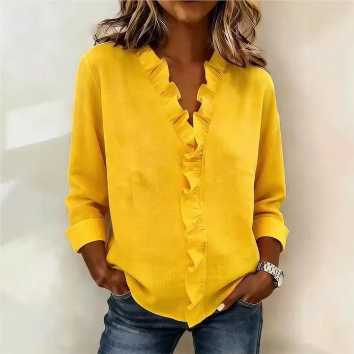 Veda Bremen Sorelle™ blouse featuring vertical ruffle detail and timeless style, shown in a close-up of the elegant fabric and design.