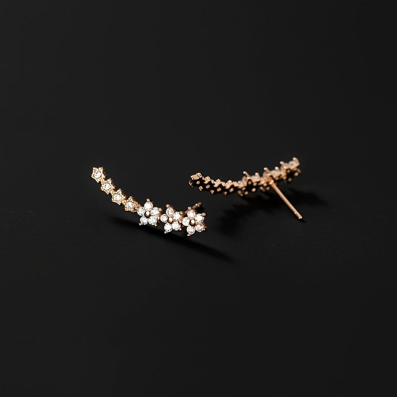 Veda Bremen timeless floral earrings featuring delicate flower designs in gold-tone metal on a white background.