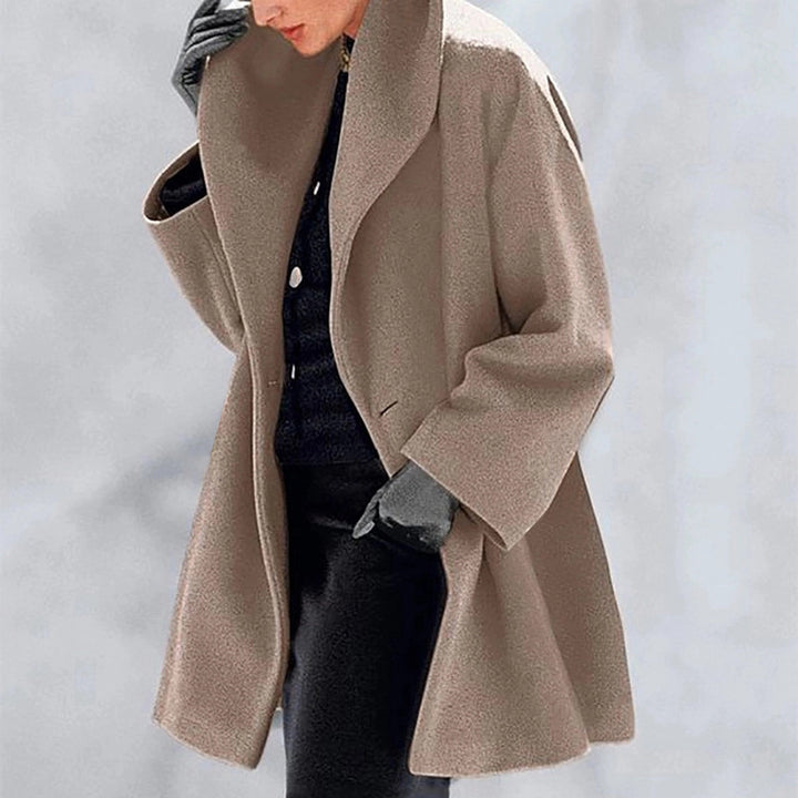 Camel Cocoon Winter Coat by Lurolondon.co.uk hanging on a rack, showcasing its cozy, oversized design and warm winter fabric.