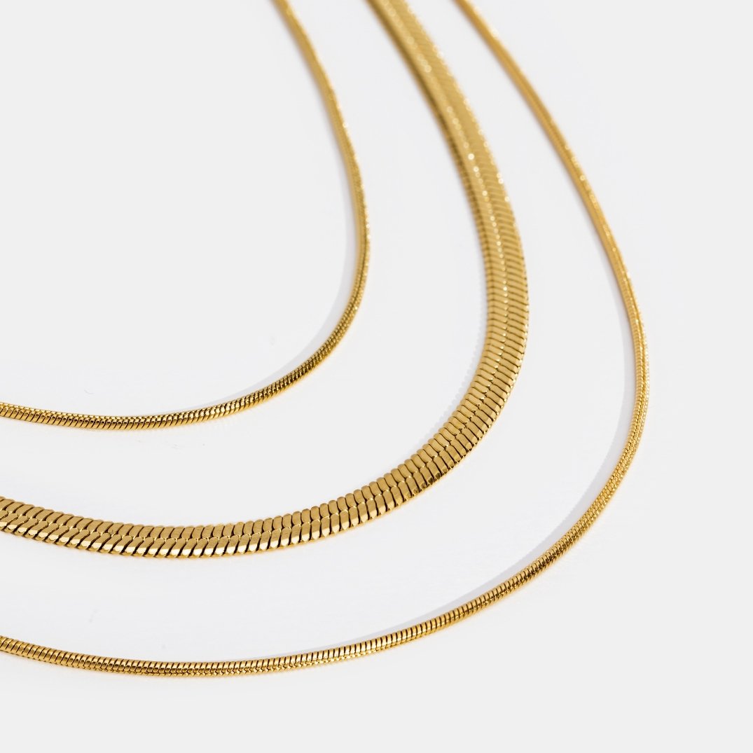 Veda Bremen multi-layered gold chain necklace with delicate overlapping links on a white background.