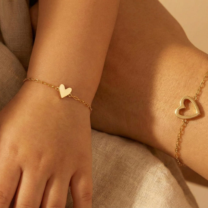 Veda Bremen Herzen Armband Set featuring layered gold-tone bracelets with heart charms and delicate chain details.