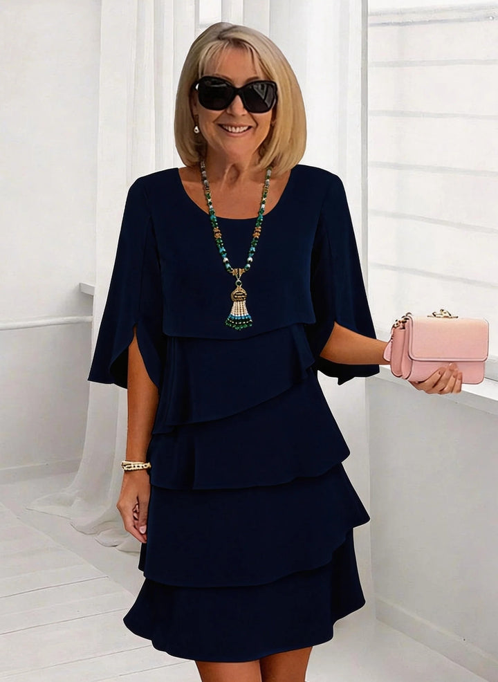 Navy blue Schichtkleid mit Rüschen by Veda Bremen, featuring layered fabric and ruffle details, perfect for elegant occasions.